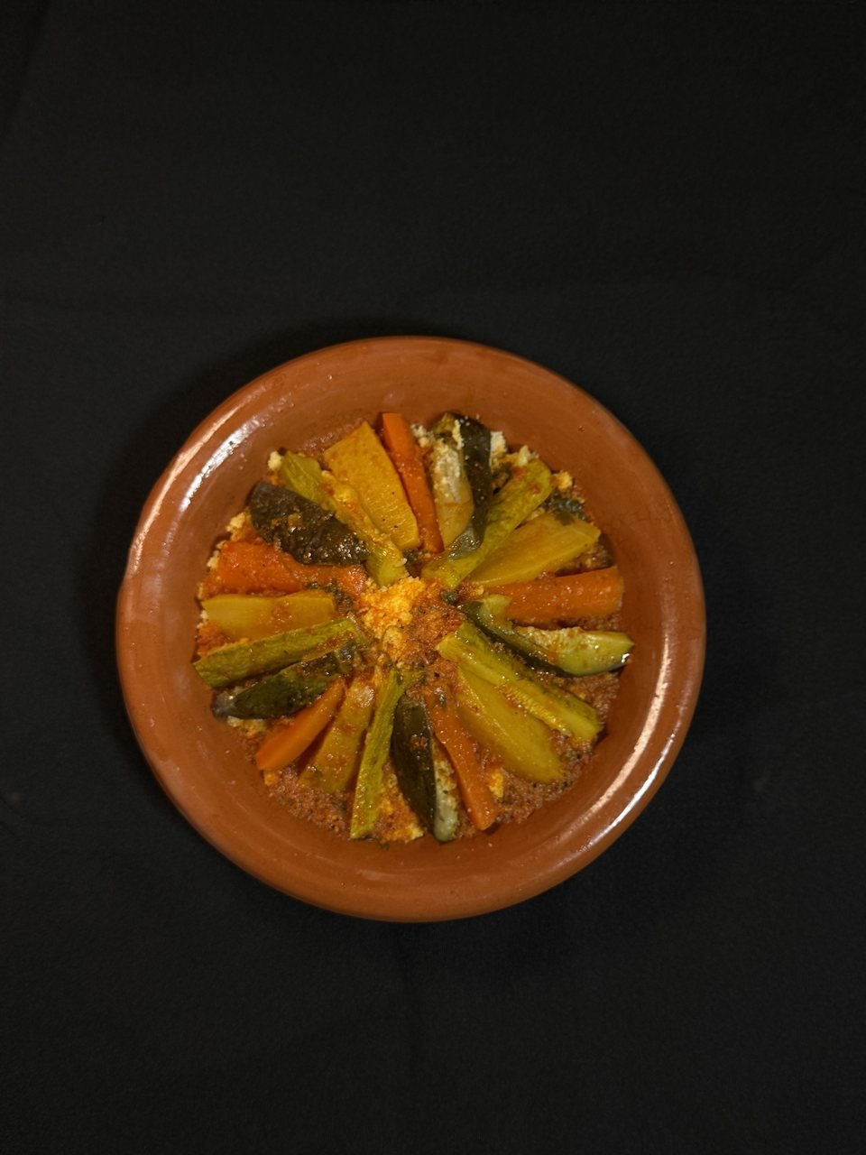 Seven-vegetable couscous in a traditional clay dish, seen from above