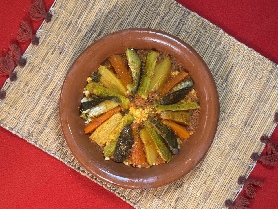 Couscous served on a woven mat over the signature red table