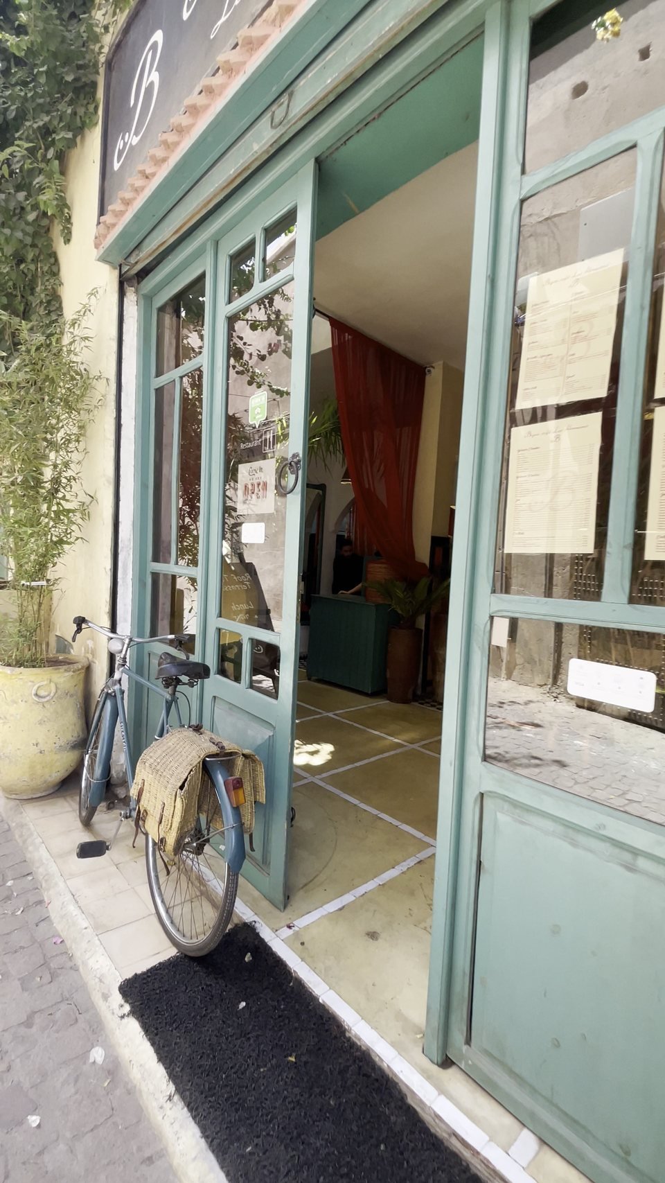 The teal-green doors of Bigua Café, looking into the salon