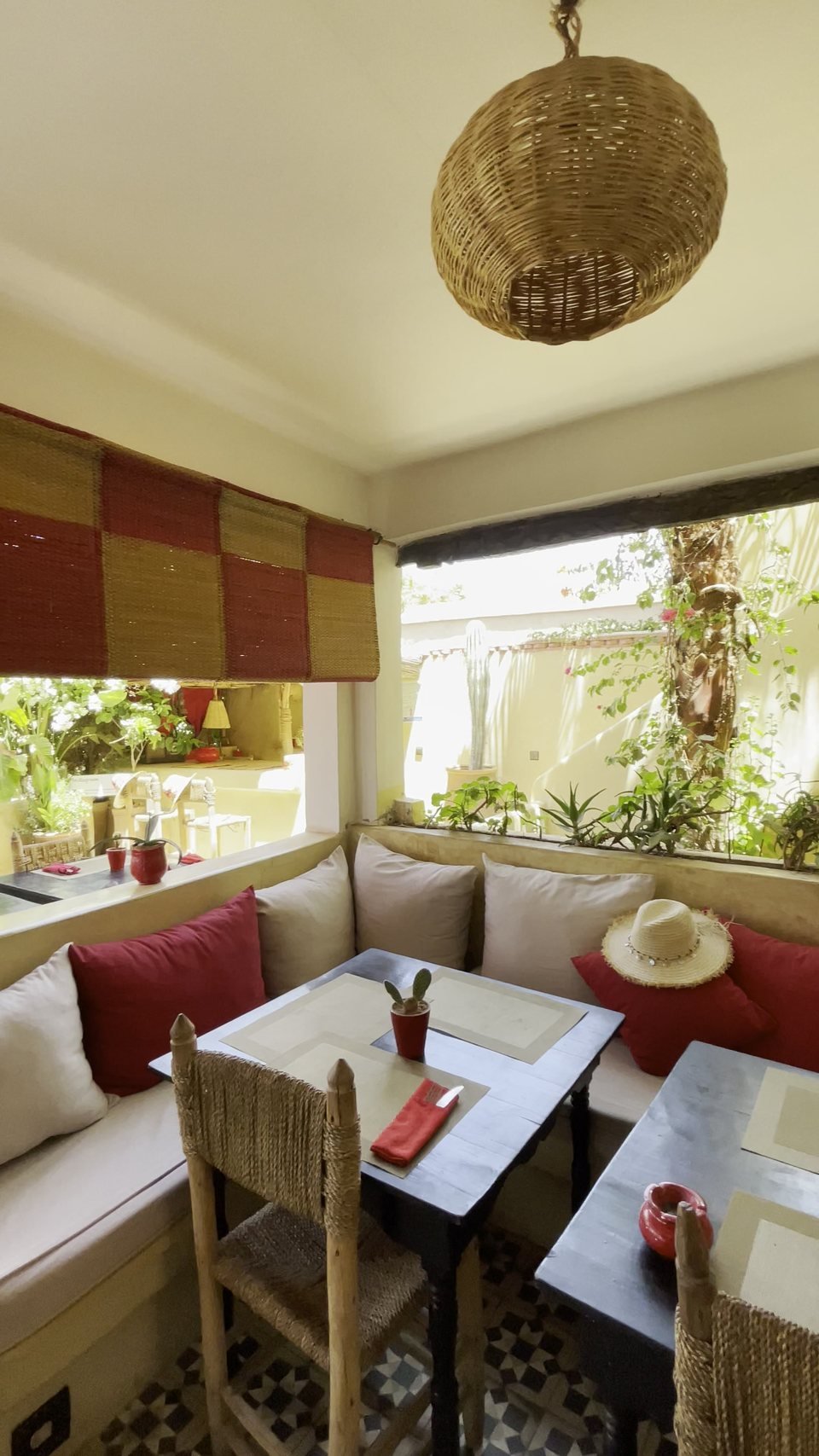 A cosy banquette nook with cushions, a low table and a rattan lamp