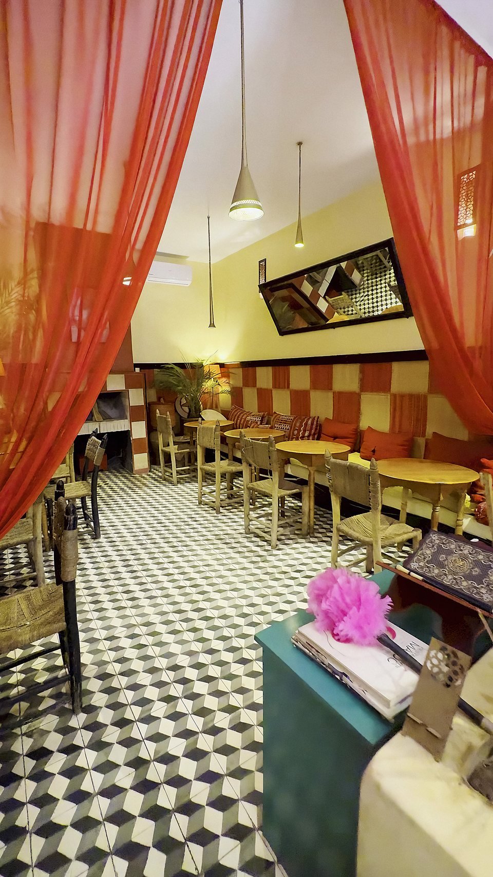 The salon of Bigua Café: red voile drapes and traditional tiled floor