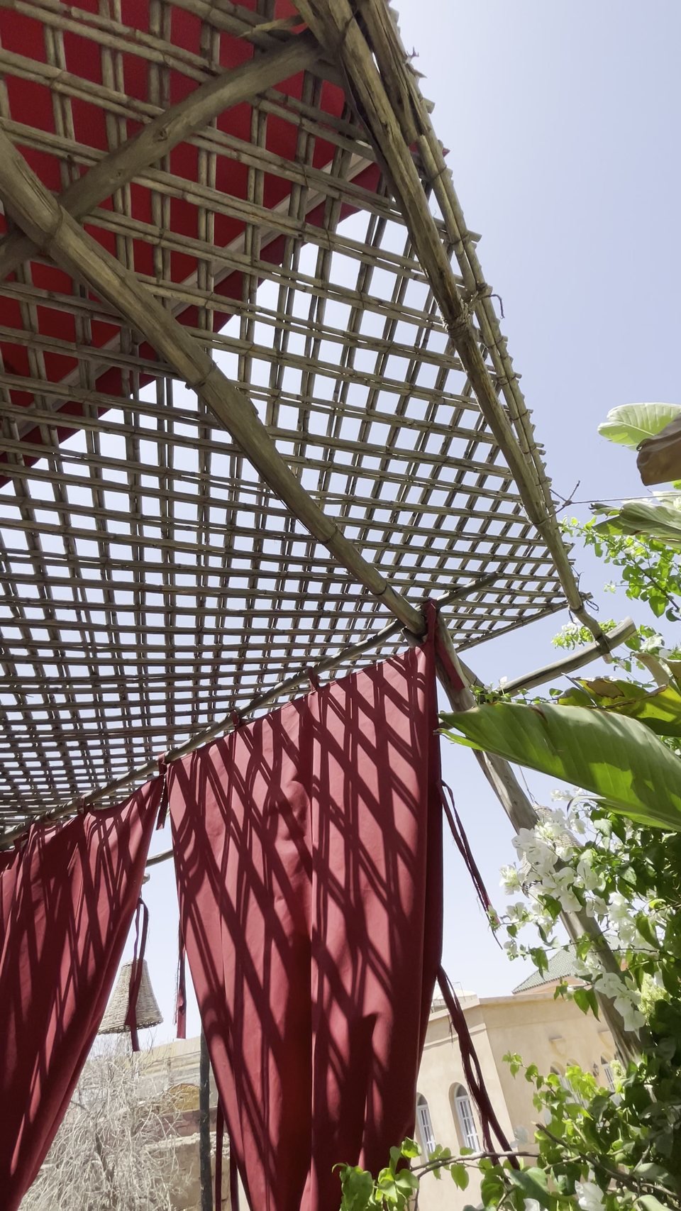 La terrasse du Bigua Café sous sa canisse, lanternes et voilages rouges